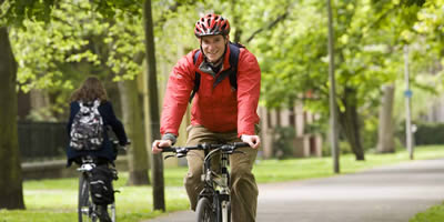 Member of staff cycling in the Meadows