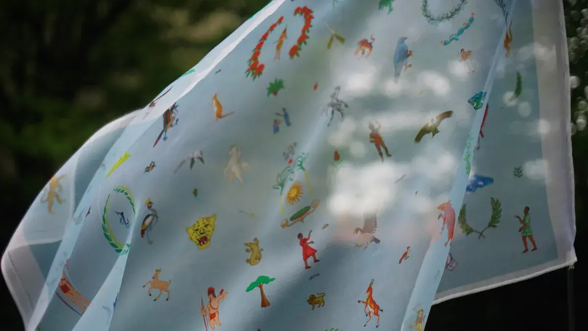 A textile flag featuring emblems from 60 countries blows in the wind. 