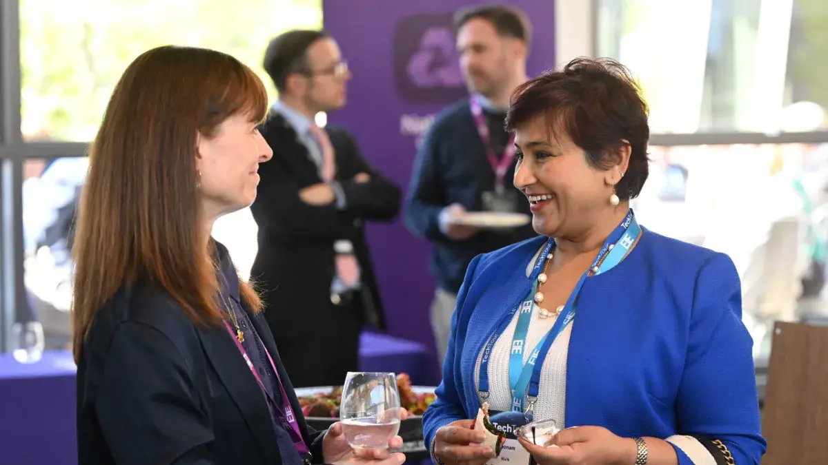 Two delegates network at the EIE25 tech conference.
