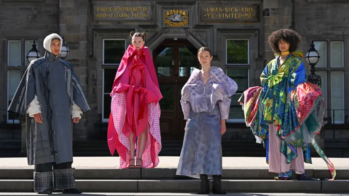Four models posed outside the Edinburgh Futures Institute wearing designs from this year's ECA Fashion Show.