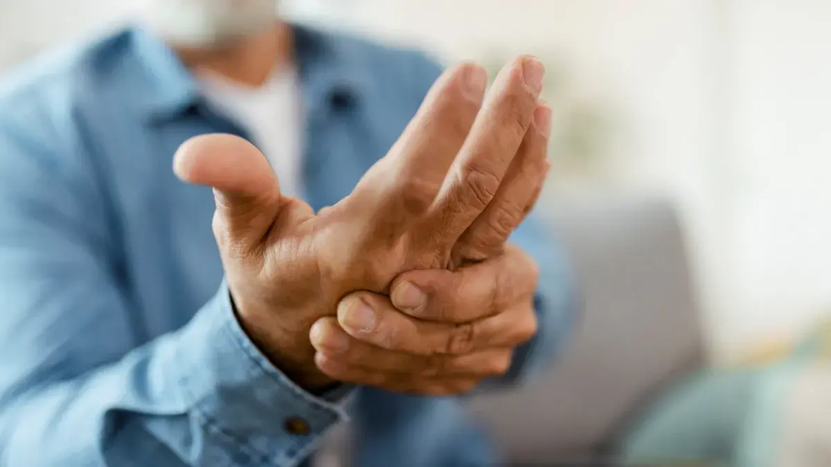 Close up of older man massaging hand