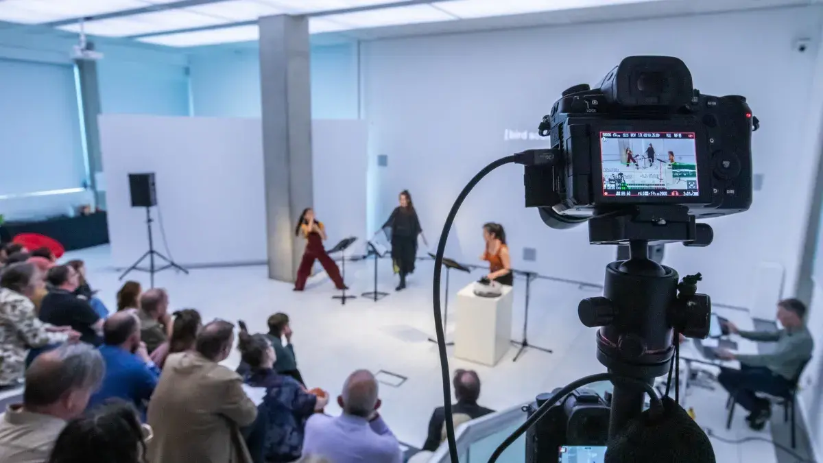 An audience takes part in an event in the white box interior of the InSpace gallery.