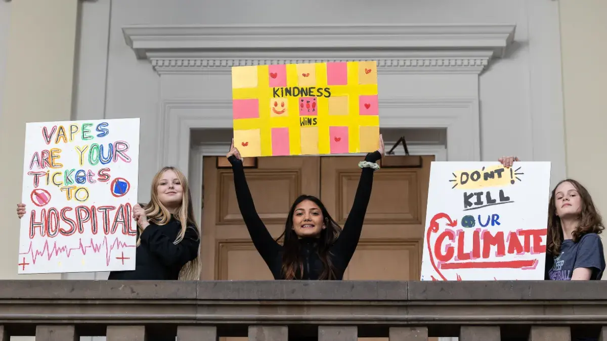 Three of the Children's Parliament with their placards pictured at Edinburgh College of Art.