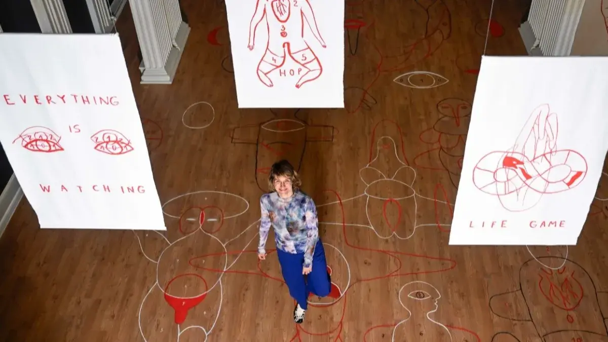 Czech artist Adéla Součková pictured with her giant hopscotch boards on the floor of the Talbot Rice Gallery that can be enjoyed by visitors of all ages.