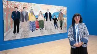 Artist Małgorzata Mirga-Tas pictured with one of her artworks at the Talbot Rice Gallery