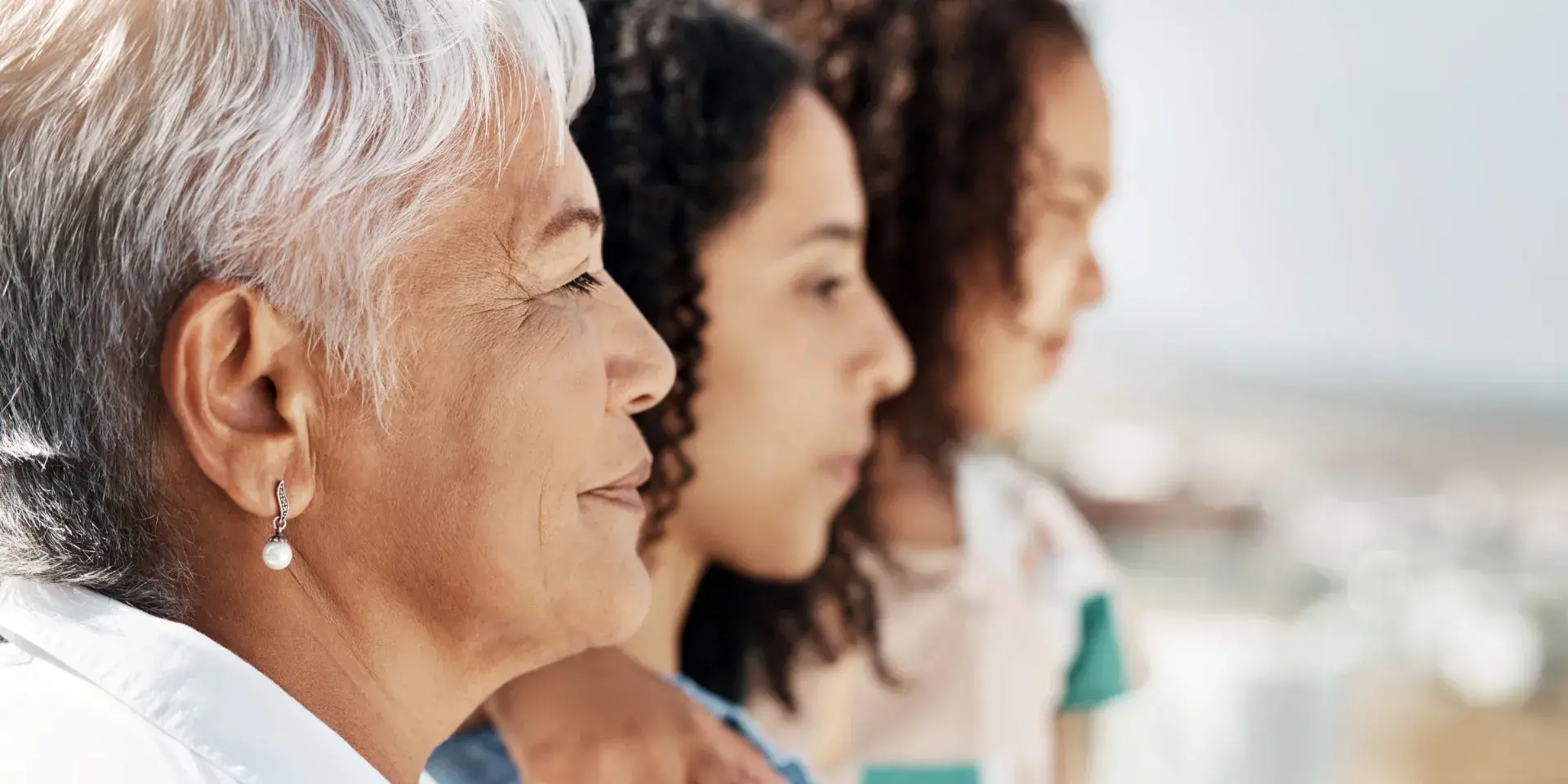 Side profile of Brazilian grandmother, mother and child, with neutral expressions