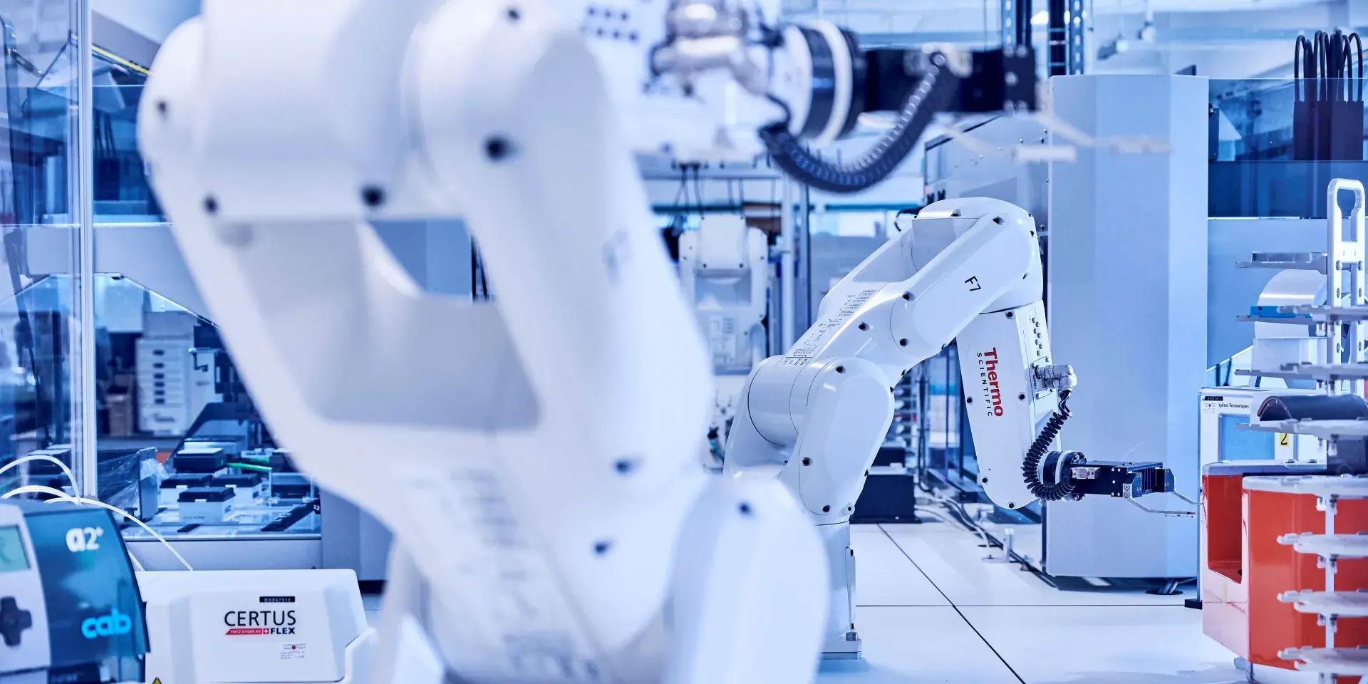 Two white robot arms moving objects