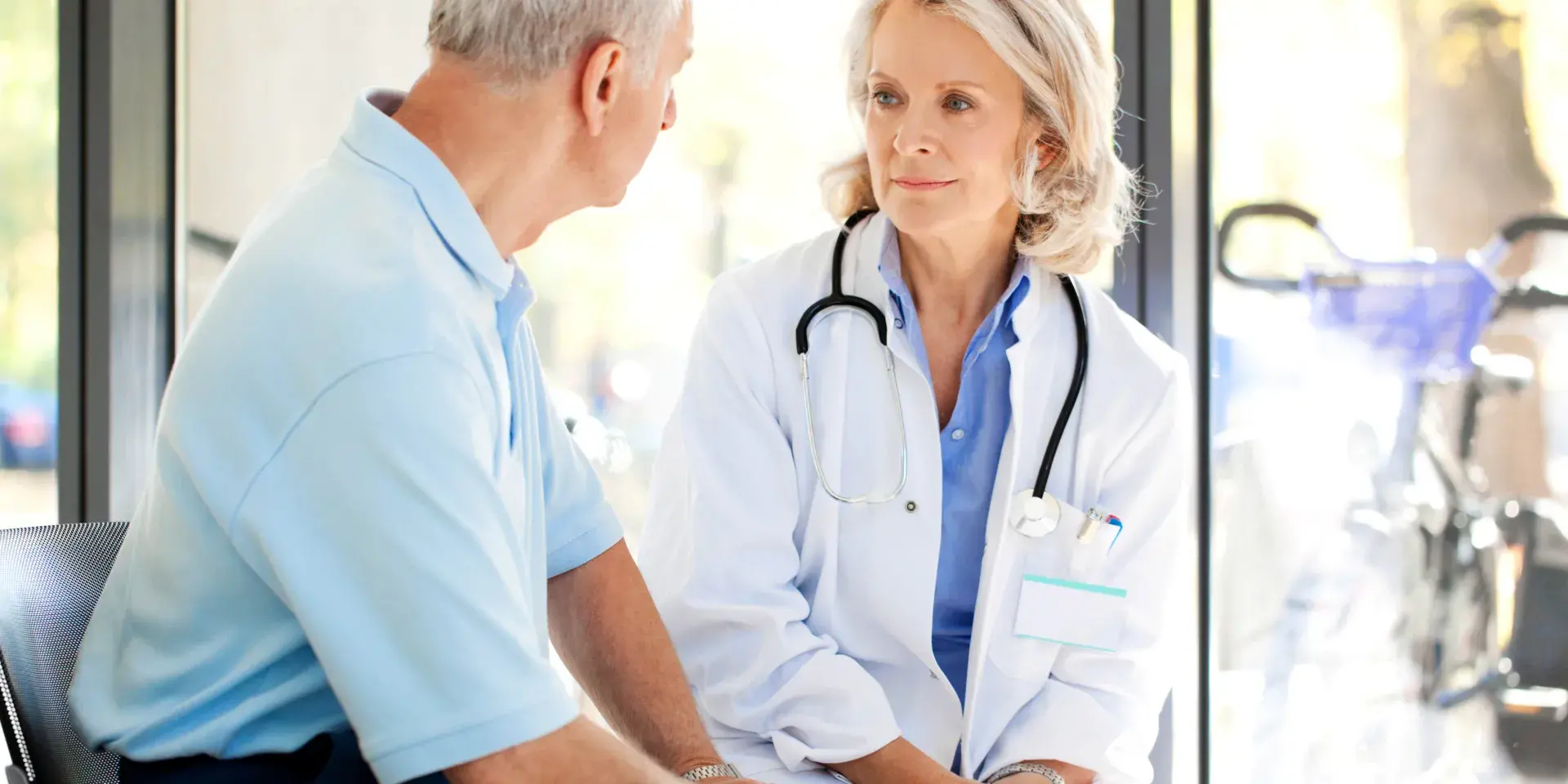 A female doctor talking to an elderly man
