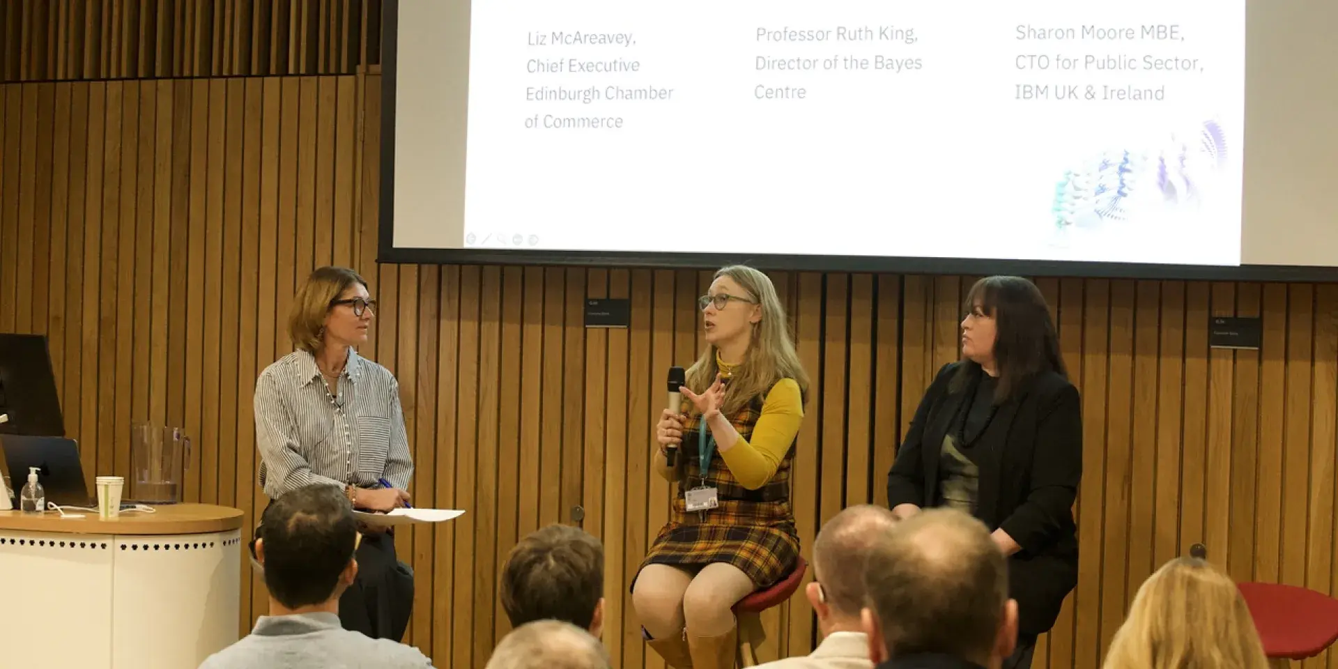 Picture of three women on a panel in front of an audience at an IBM event. Liz McAreavey is host, with Ruth King and Sharon Moore being questioned.