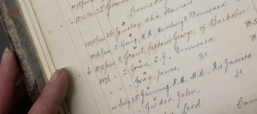 Close up image of a person leafing through old records in the University's Centre for Research Collections