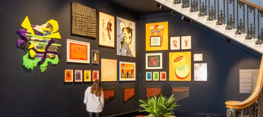A person stands and looks at artwork at the bottom of the stairwell in Old College, Edinburgh