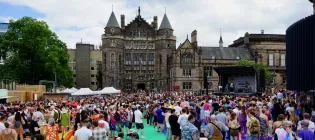Crowds at Edinburgh Pride Festival Village on Bristo Square with Teviot Row House in the background. Image taken during Pride Edinburgh 2019.