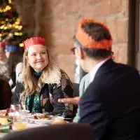 A student talks to a member of staff in front of a Christmas tree
