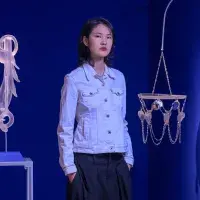 A student artist poses in front of their installation. 