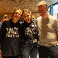 Colleagues pictured smiling at the Impact Festival