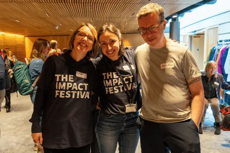 Colleagues pictured smiling at the Impact Festival