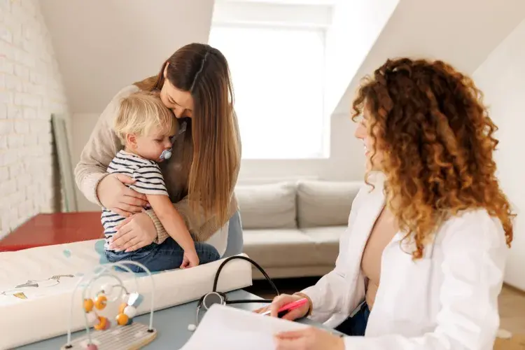 Mother and son visiting female doctor in paediatrician's office