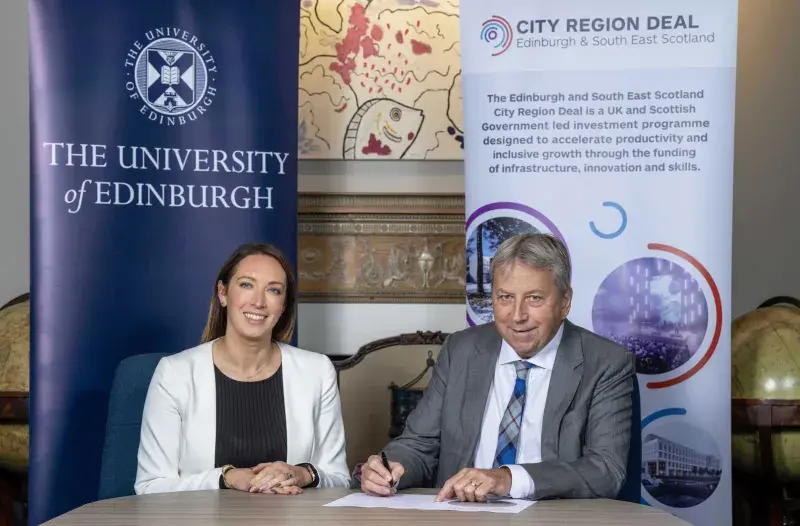 Image of Ellen Munro from Edinburgh and South East Scotland City Region Deal sitting with Peter Mathieson as he signs a Community Wealth Building Pledge
