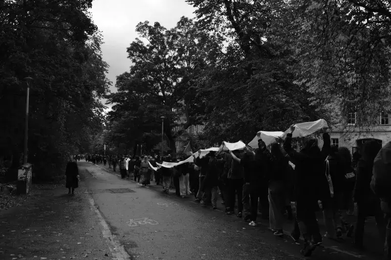People walk down Middle Meadow Walk carrying Palestinian flags