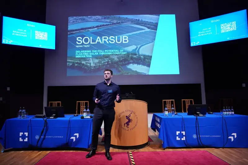 Presenter standing in front of screen saying 'SolarSub'
