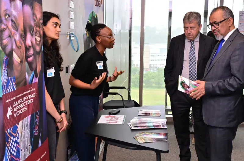 (R-L) WHO Director-General and Professor Peter Mathieson speak with two researchers during the opening of the Usher Building on Thursday 26 June 2025