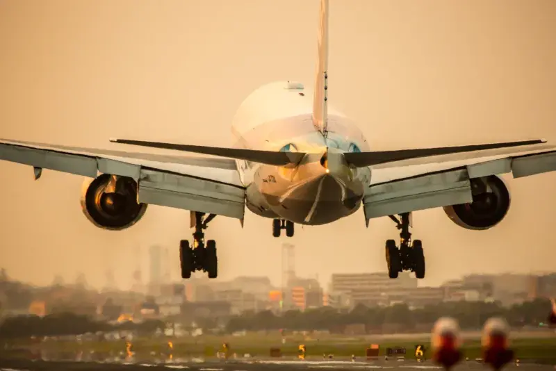 Large aeroplane taking off with buildings in the background