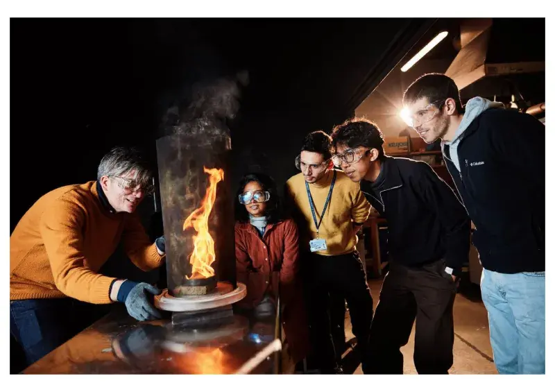 Professor teaches students in front of flame in lab 